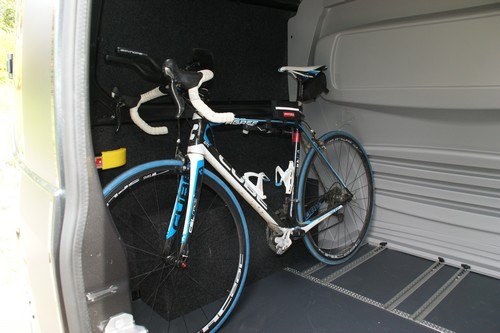 Vélo de route chargé dans un fourgon aménagé